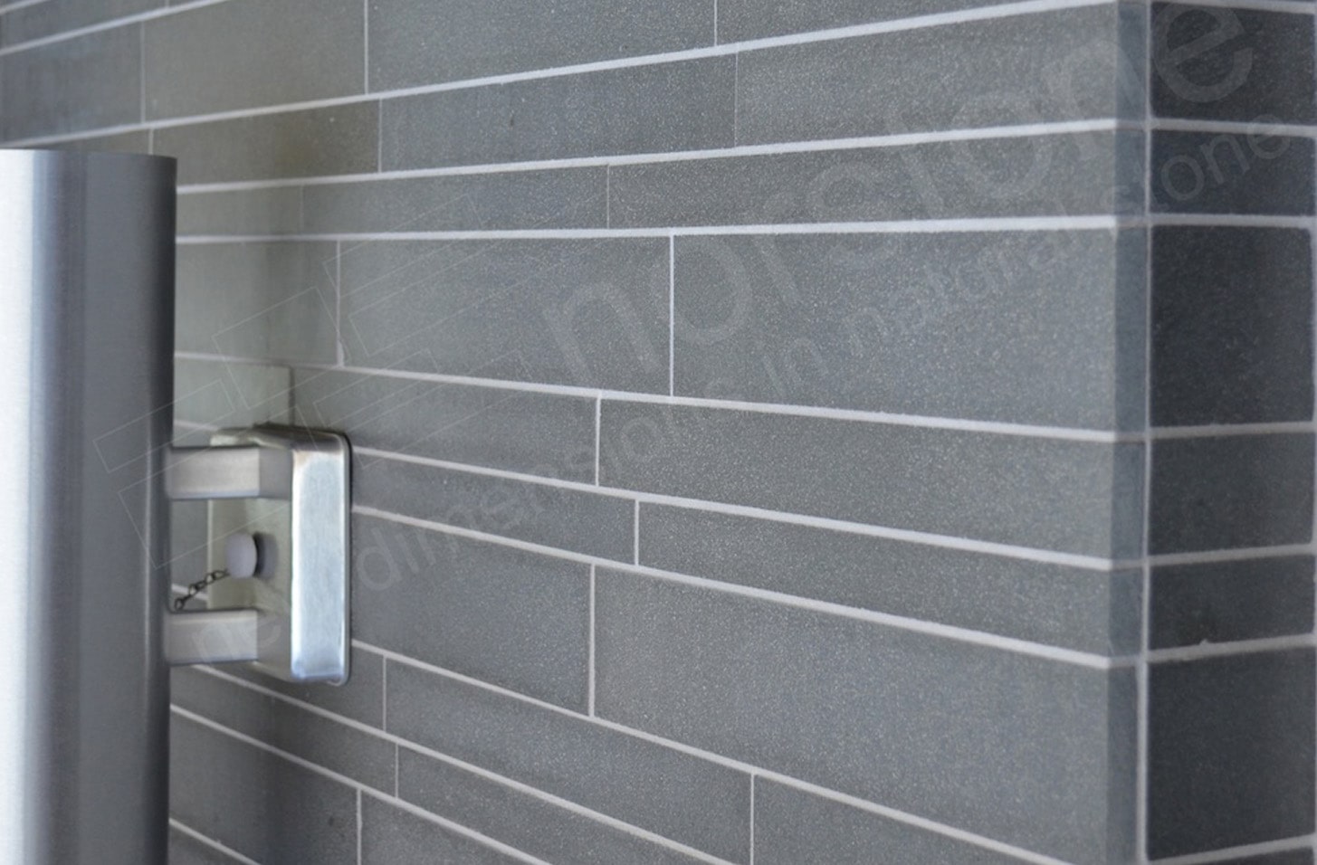 Lava Stone Basalt Interlocking medium format tile used on a wall showing an outside corner and a stainless steel light fixture